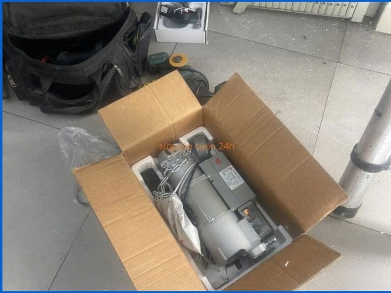 Motor cửa cuốn mới đang được kỹ thuật viên lắp đặt và kiểm tra vận hành